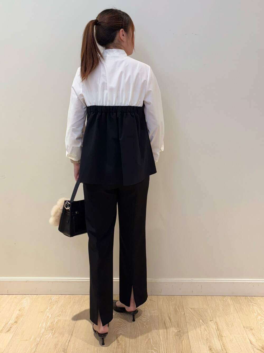 ブラック系のショルダーバッグ、ホワイト系のシャツ/ブラウス、ブラック系のその他パンツを着用したレディースの秋コーディネートの2枚目の写真
