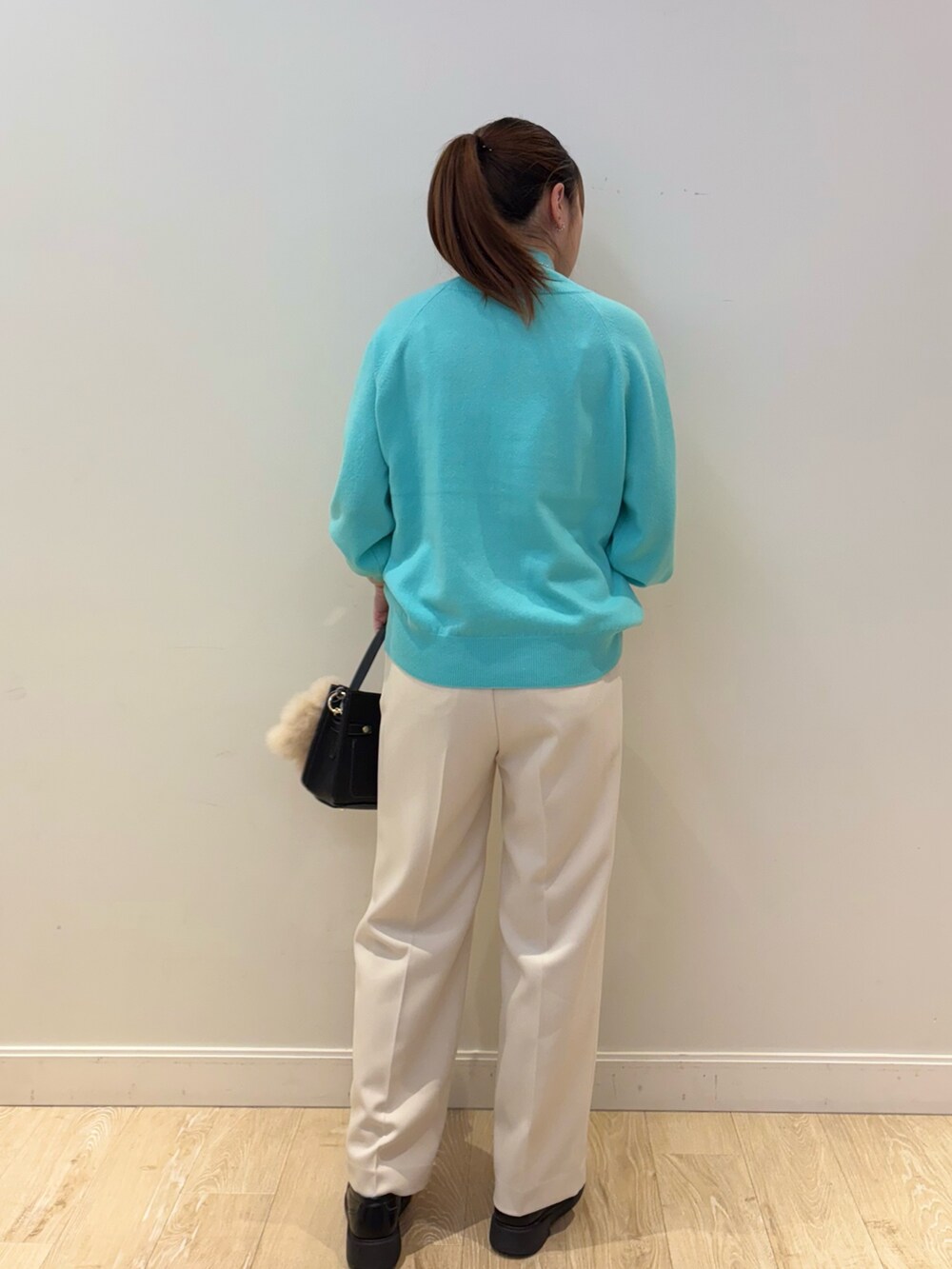 ブラック系のショルダーバッグ、ホワイト系のその他パンツ、グリーン系のニット/セーターを着用したレディースの秋コーディネートの3枚目の写真