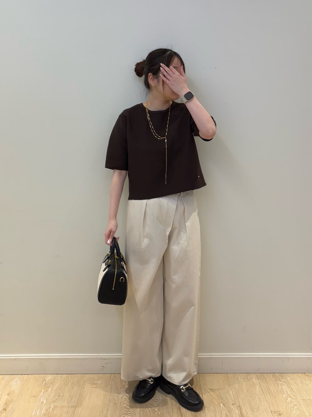 ブラック系のボストンバッグ、ブラウン系のニット/セーター、ホワイト系のその他パンツを着用したレディースの春コーディネートの4枚目の写真