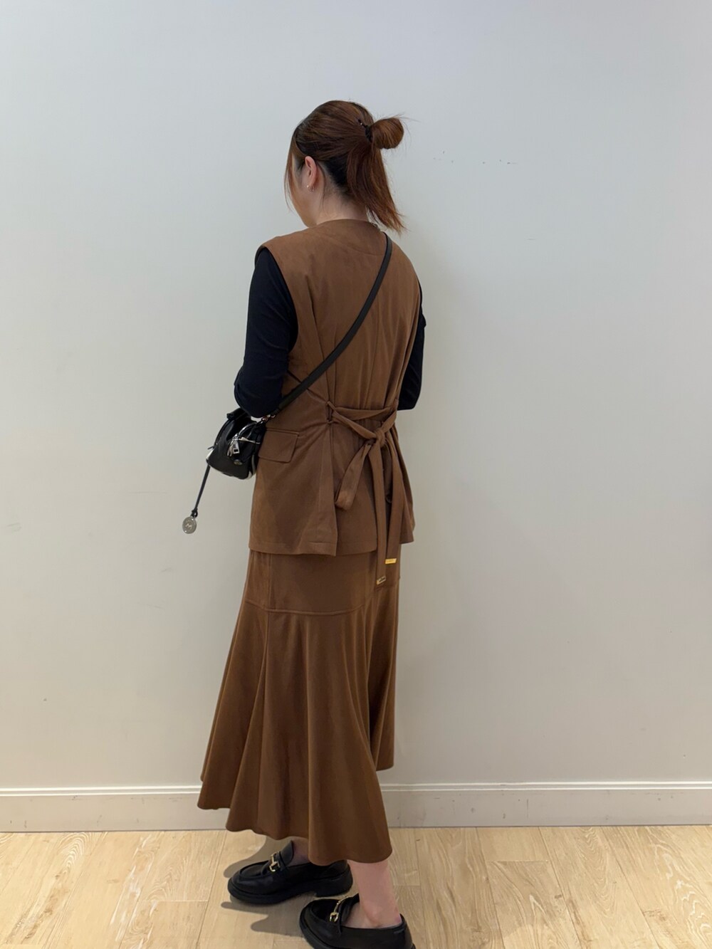 ブラウン系のスカート、その他のショルダーバッグ、ブラウン系のベストを着用したレディースの秋コーディネートの3枚目の写真