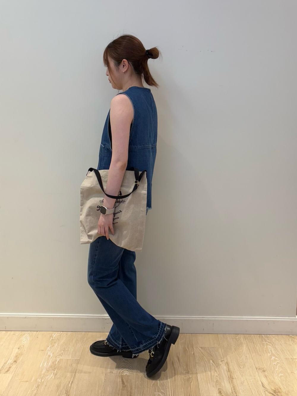 ブラック系のタンクトップ、ブラック系のバックパック/リュック、ブルー系のベストを着用したレディースの夏コーディネートの4枚目の写真