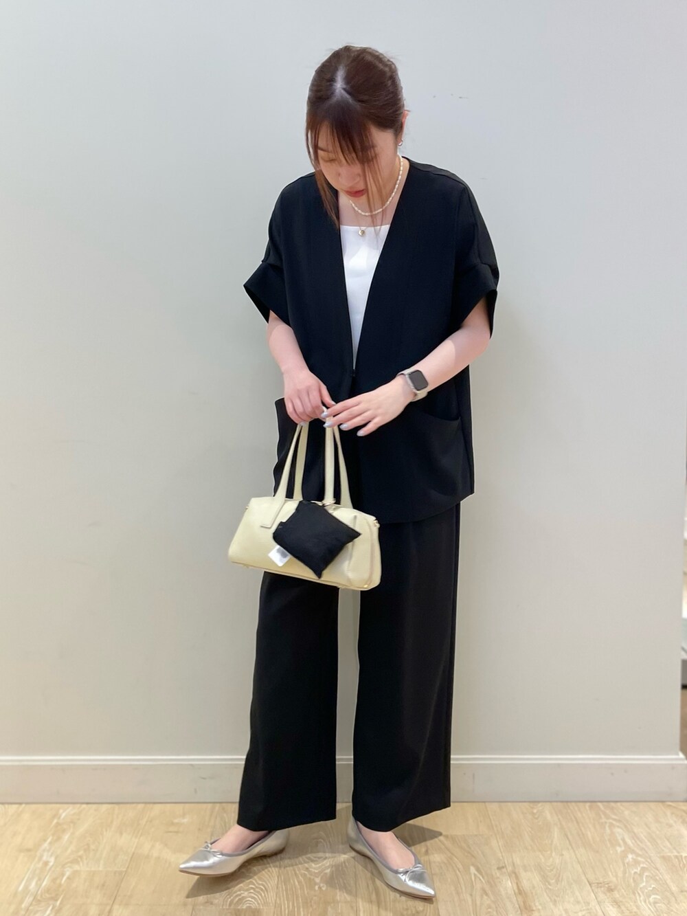 ブラック系のボストンバッグ、ブラック系のその他パンツ、ホワイト系のタンクトップを着用したレディースの春コーディネートの2枚目の写真