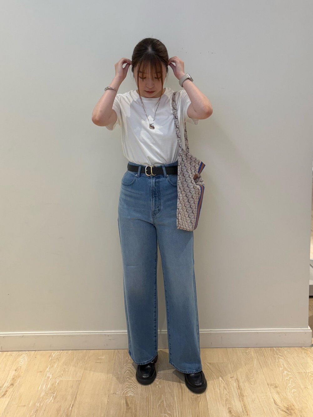 ブルー系のデニムパンツ、ブルー系のショルダーバッグ、ホワイト系のTシャツ/カットソーを着用したレディースの夏コーディネートの3枚目の写真