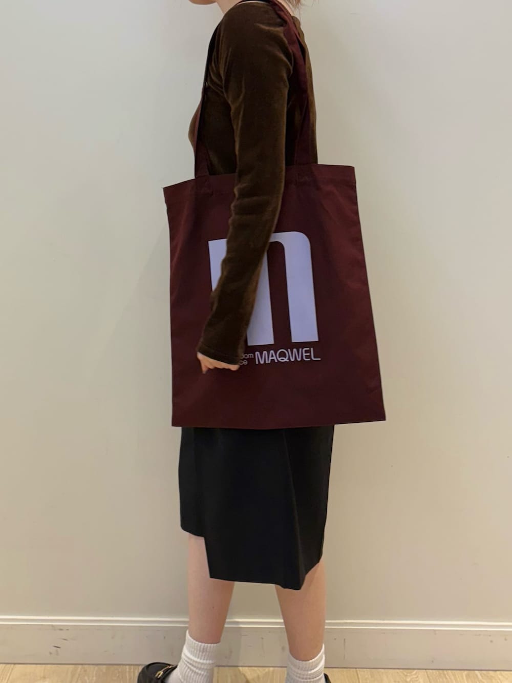 ブラウン系のTシャツ/カットソー、ブラック系のその他パンツ、レッド系のトートバッグを着用したレディースの秋コーディネートの2枚目の写真
