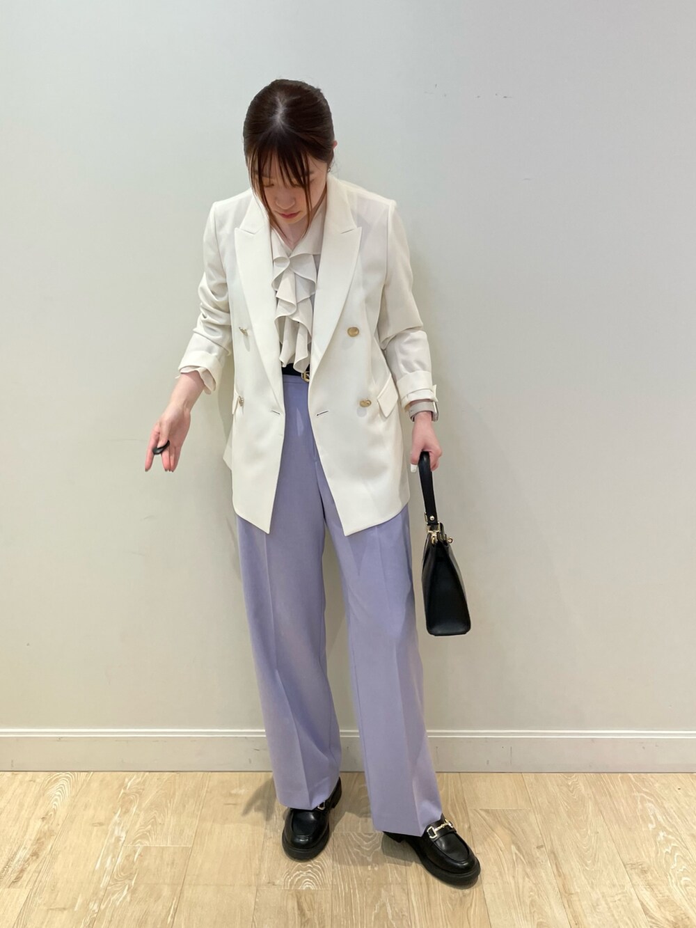 ブラック系のショルダーバッグ、ブルー系のシャツ/ブラウス、ホワイト系のテーラードジャケットを着用したレディースの春コーディネートの3枚目の写真