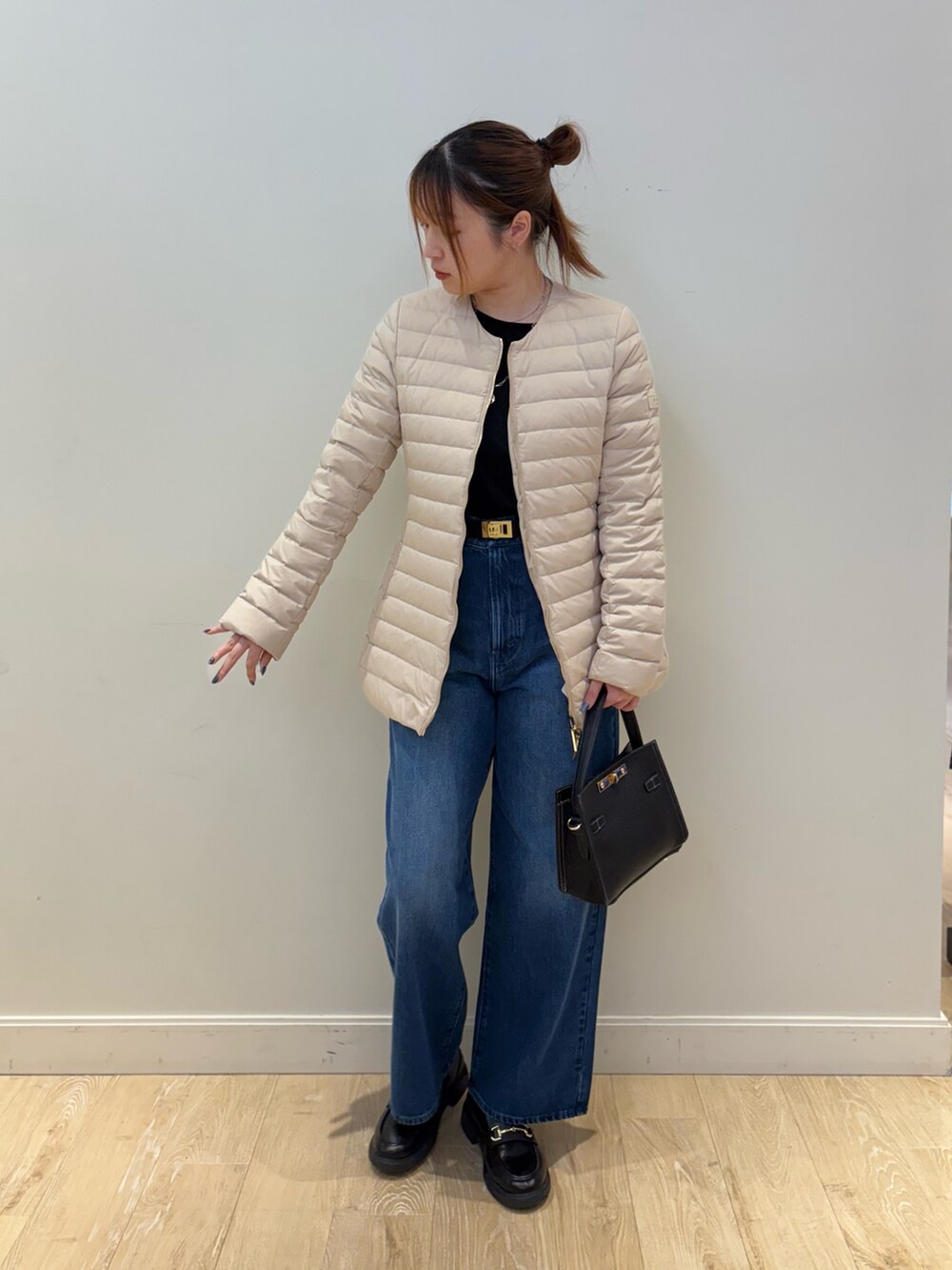 ブルー系のデニムパンツ、ブラック系のショルダーバッグ、ブラック系のTシャツ/カットソーを着用したレディースの秋コーディネートの3枚目の写真