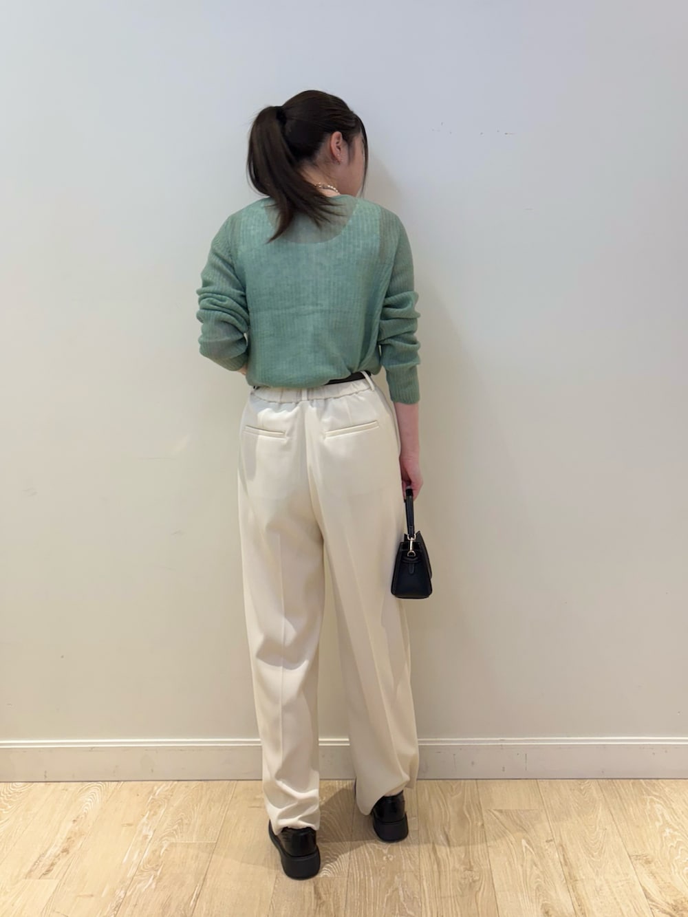 ブラック系のショルダーバッグ、ホワイト系のその他パンツ、ホワイト系のタンクトップを着用したレディースの冬コーディネートの2枚目の写真