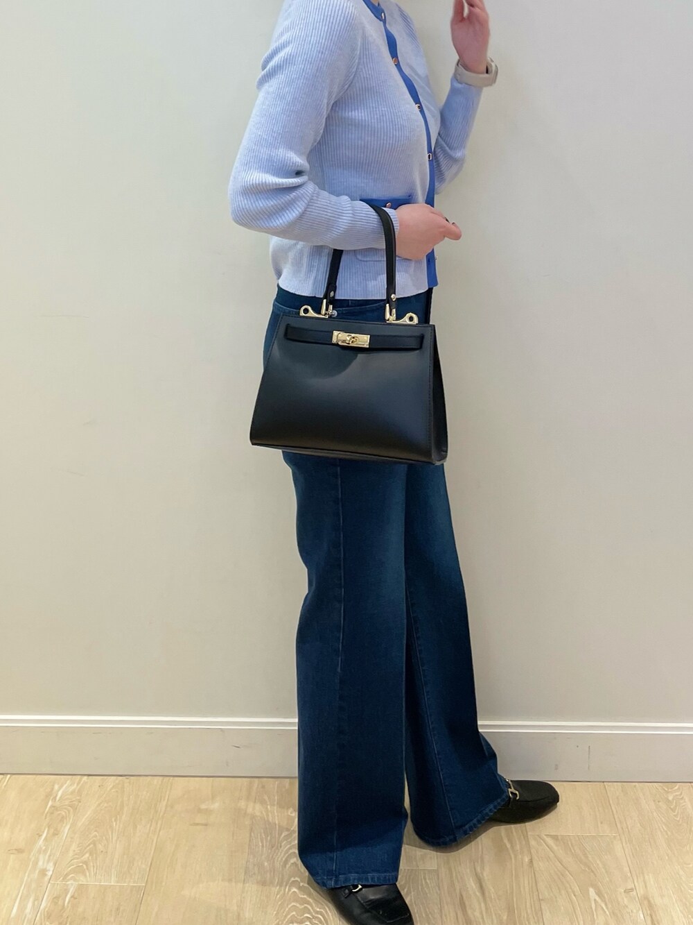 ブルー系のデニムパンツ、ブルー系のカーディガン/ボレロ、ブラック系のショルダーバッグを着用したレディースの冬コーディネートの2枚目の写真