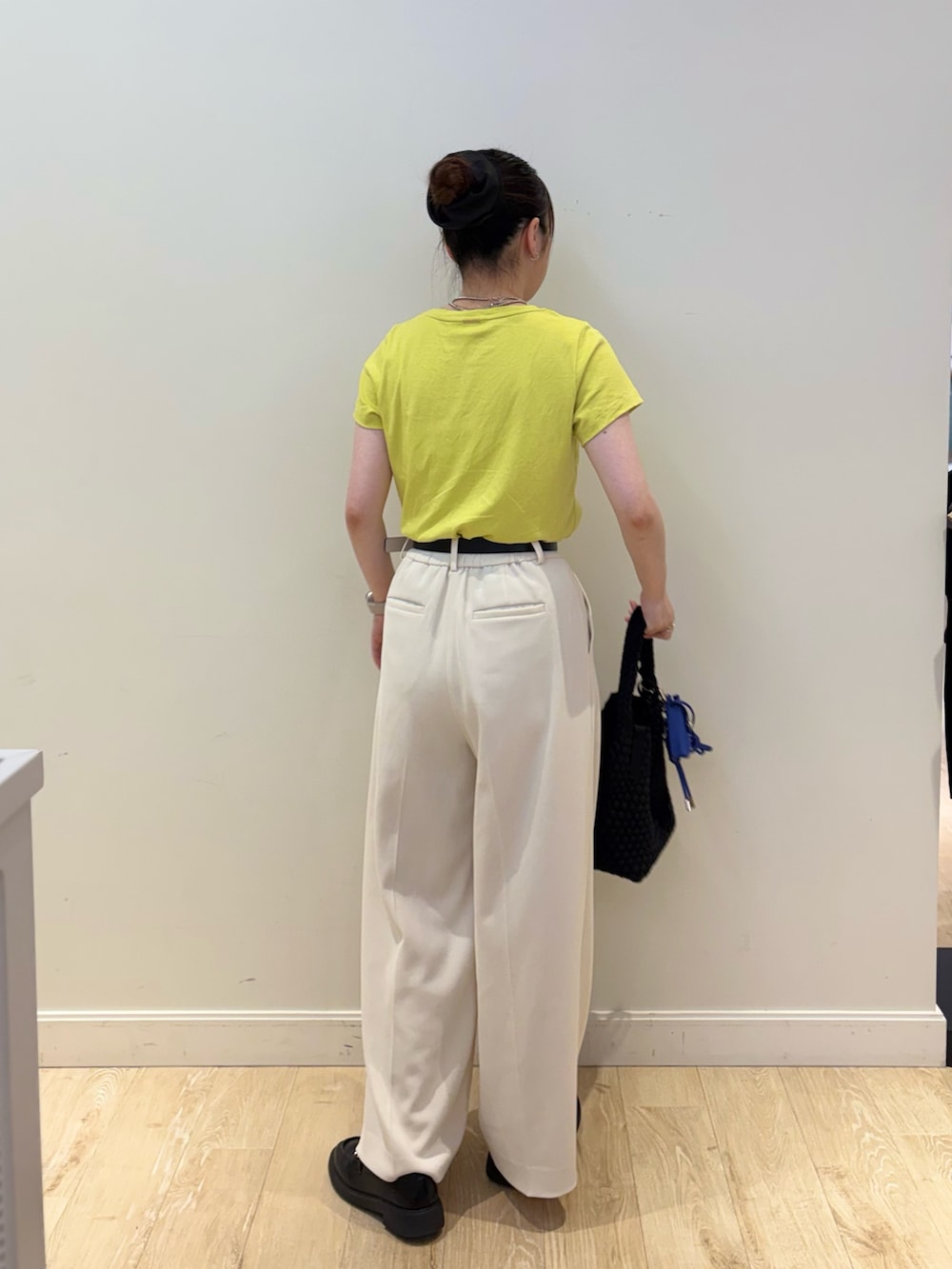 ブラック系のショルダーバッグ、ホワイト系のその他パンツ、イエロー系のTシャツ/カットソーを着用したレディースの夏コーディネートの2枚目の写真