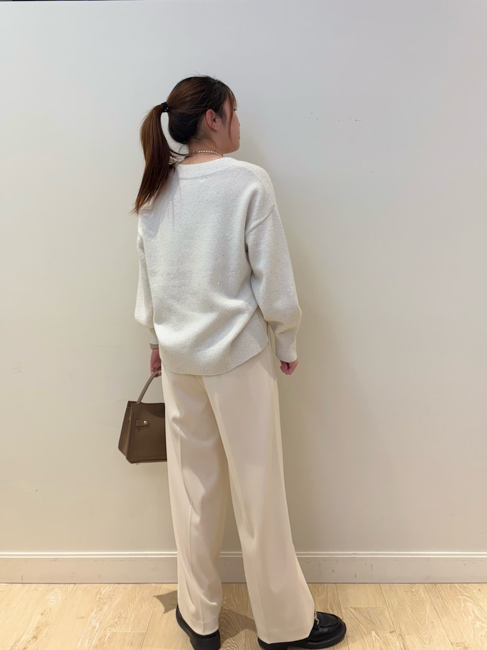 ベージュ系のショルダーバッグ、ホワイト系のその他パンツ、ホワイト系のニット/セーターを着用したレディースの冬コーディネートの2枚目の写真
