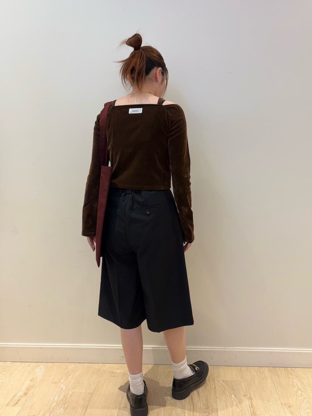 ブラウン系のTシャツ/カットソー、ブラック系のその他パンツ、レッド系のトートバッグを着用したレディースの秋コーディネートの3枚目の写真