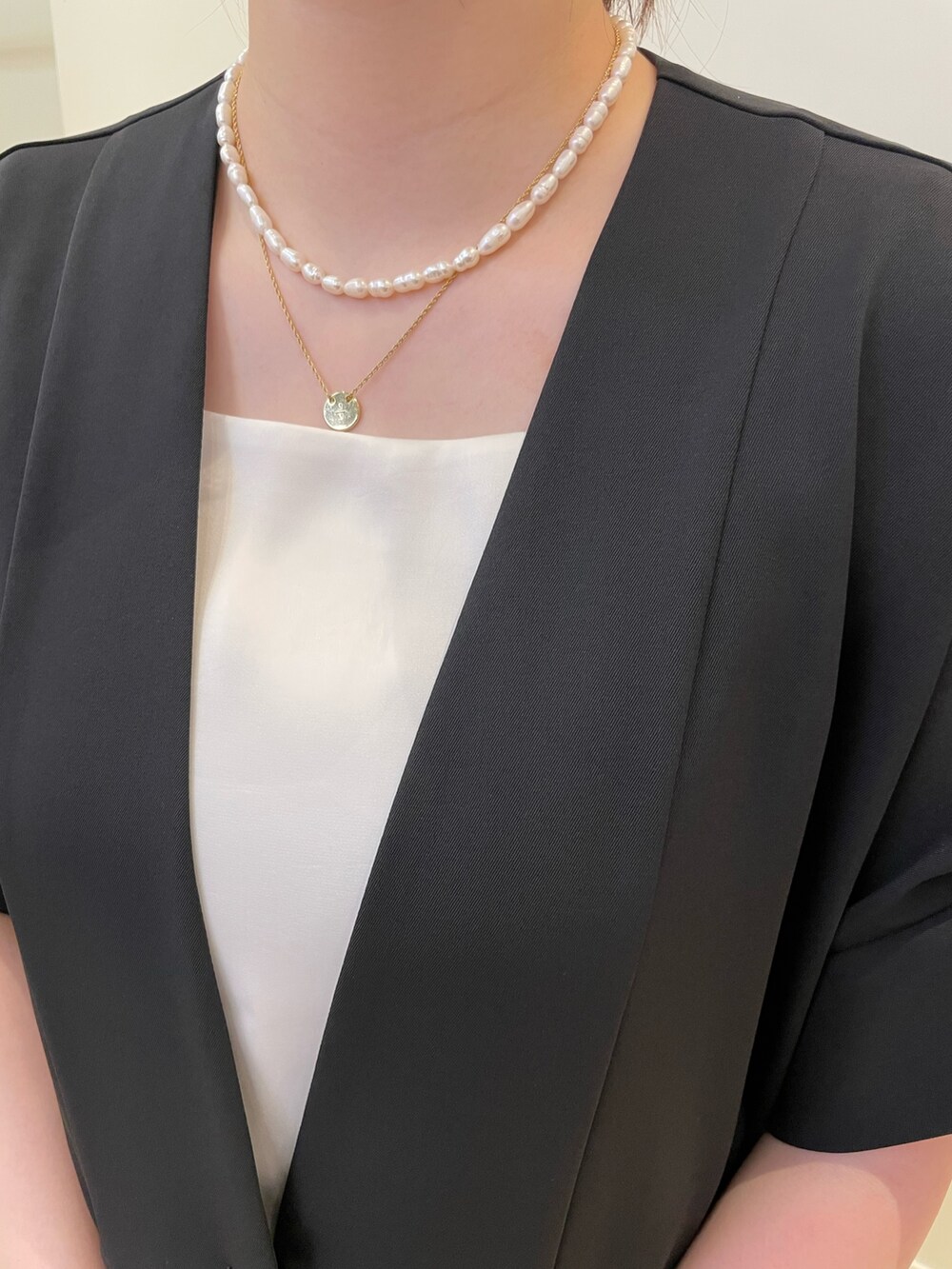 ブラック系のボストンバッグ、ブラック系のその他パンツ、ホワイト系のタンクトップを着用したレディースの春コーディネートの5枚目の写真