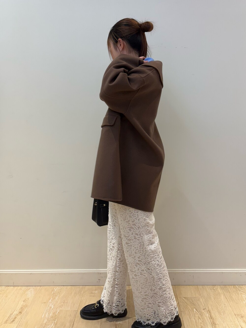 ブラック系のショルダーバッグ、ブラウン系のその他アウター、ブルー系のシャツ/ブラウスを着用したレディースの冬コーディネートの3枚目の写真