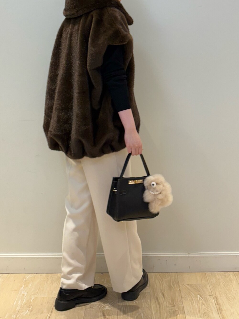ブラック系のニット/セーター、ブラック系のショルダーバッグ、ホワイト系のその他パンツを着用したレディースの秋コーディネートの3枚目の写真