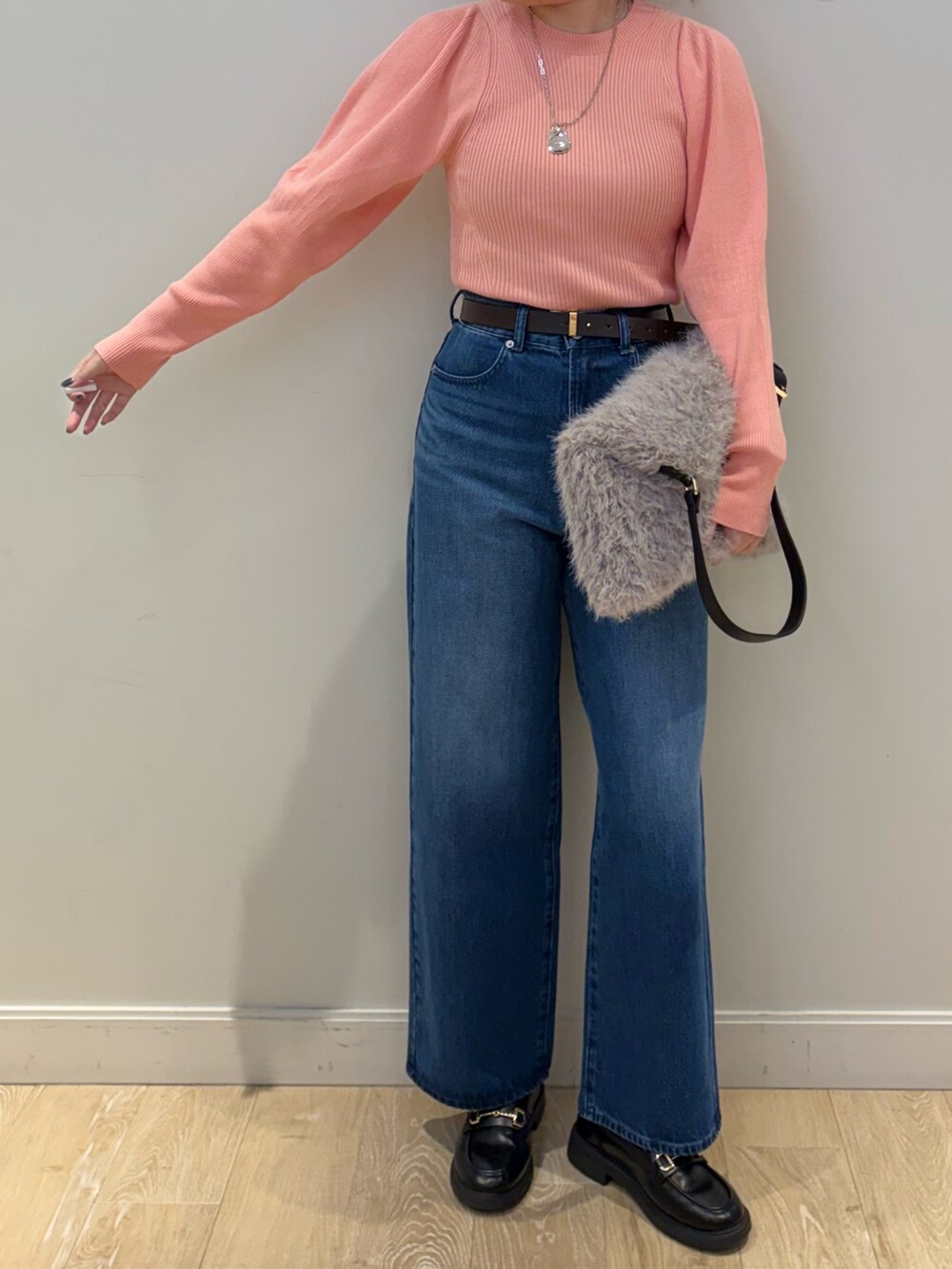 ブルー系のデニムパンツ、ベージュ系のショルダーバッグ、ピンク系のニット/セーターを着用したレディースの秋コーディネートの4枚目の写真