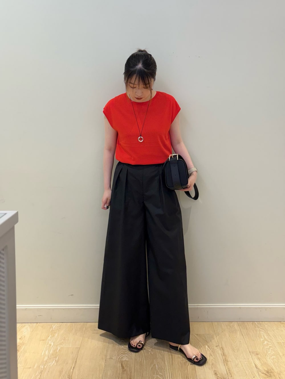ブラック系のその他パンツ、ブラック系のショルダーバッグ、レッド系のニット/セーターを着用したレディースの夏コーディネートの5枚目の写真