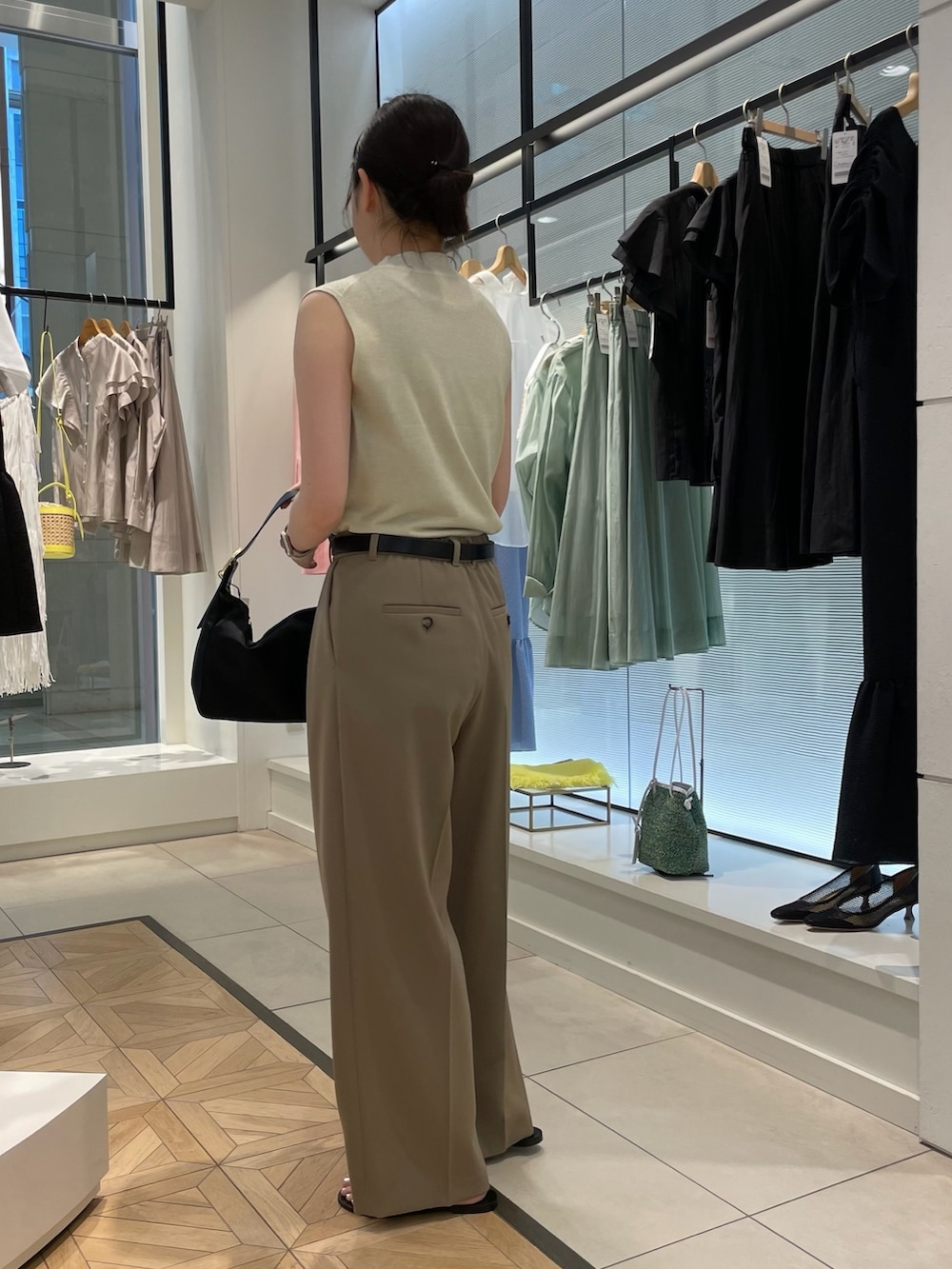 ゴールド系のニット/セーター、グリーン系のその他パンツ、ブラック系のショルダーバッグを着用したレディースの春コーディネートの4枚目の写真