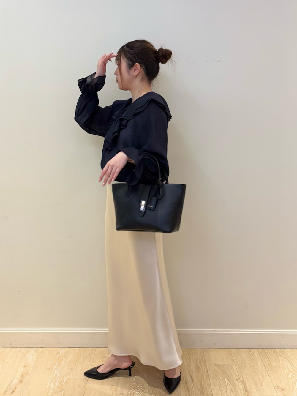ブラック系のトートバッグ、ホワイト系のタンクトップ、ブルー系のシャツ/ブラウスを着用したレディースの春コーディネートの2枚目の写真