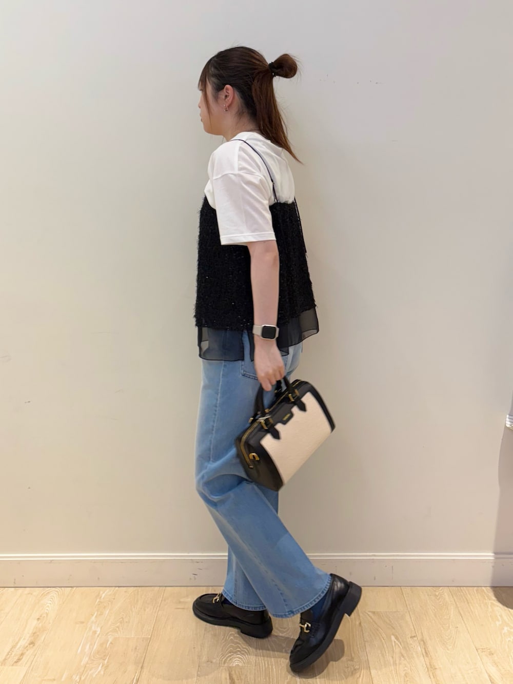 ブラック系のボストンバッグ、ホワイト系のTシャツ/カットソー、ブラック系のシャツ/ブラウスを着用したレディースの春コーディネートの2枚目の写真