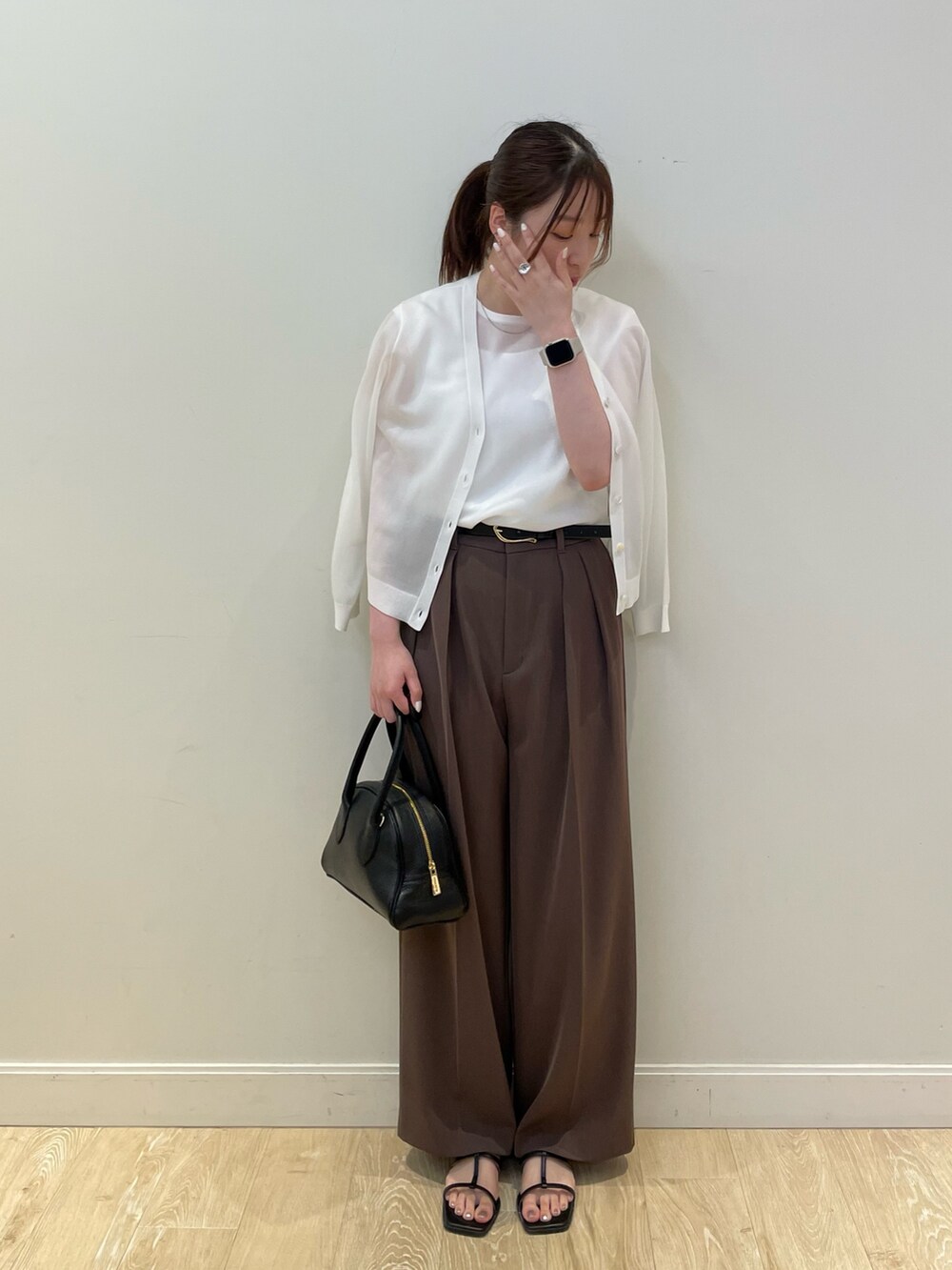 ブラック系のボストンバッグ、ホワイト系のタンクトップ、ブラウン系のその他パンツを着用したレディースの春コーディネートの2枚目の写真