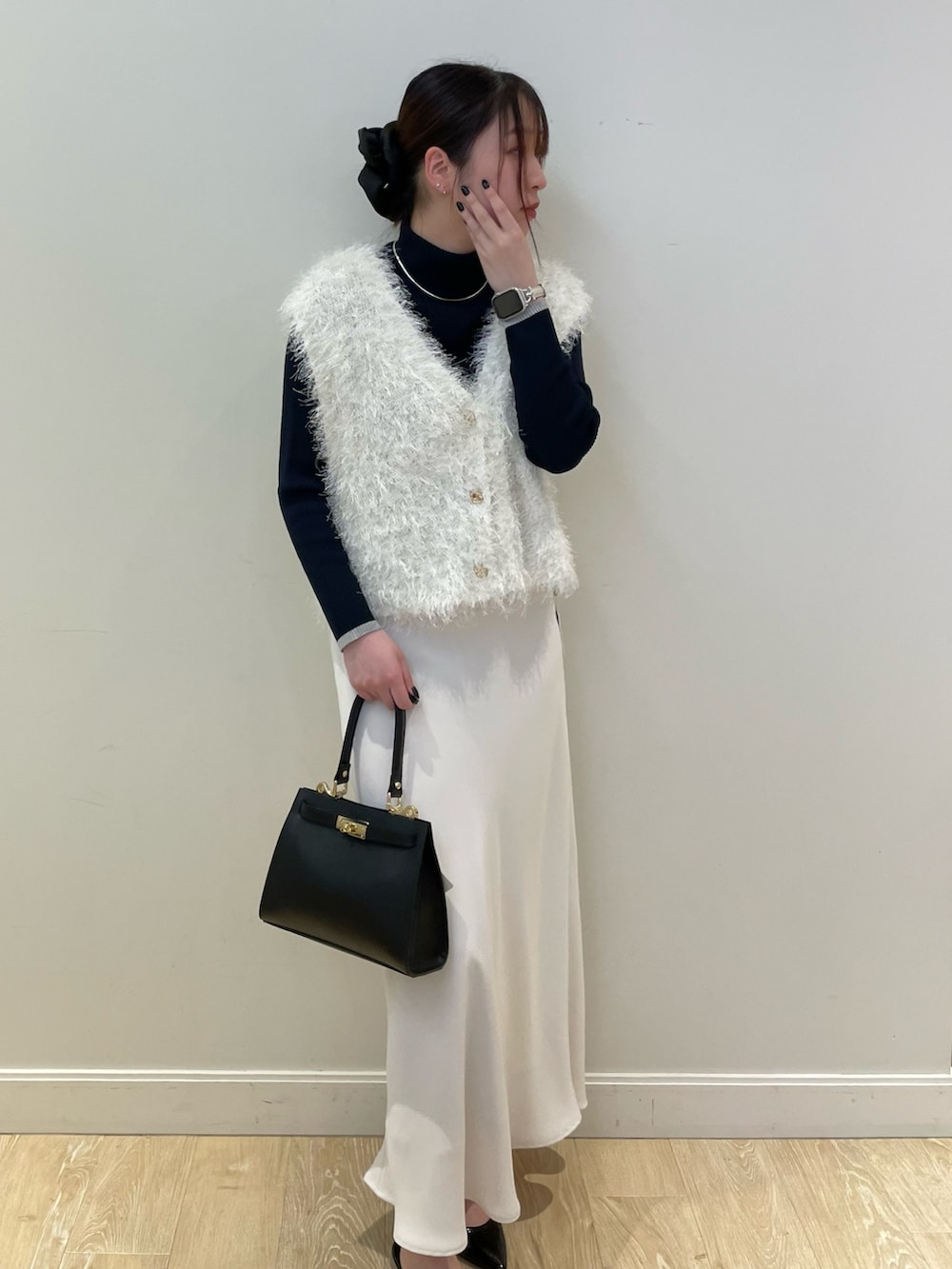 ホワイト系のベスト、ブルー系のニット/セーター、ホワイト系のスカートを着用したレディースの冬コーディネートの5枚目の写真
