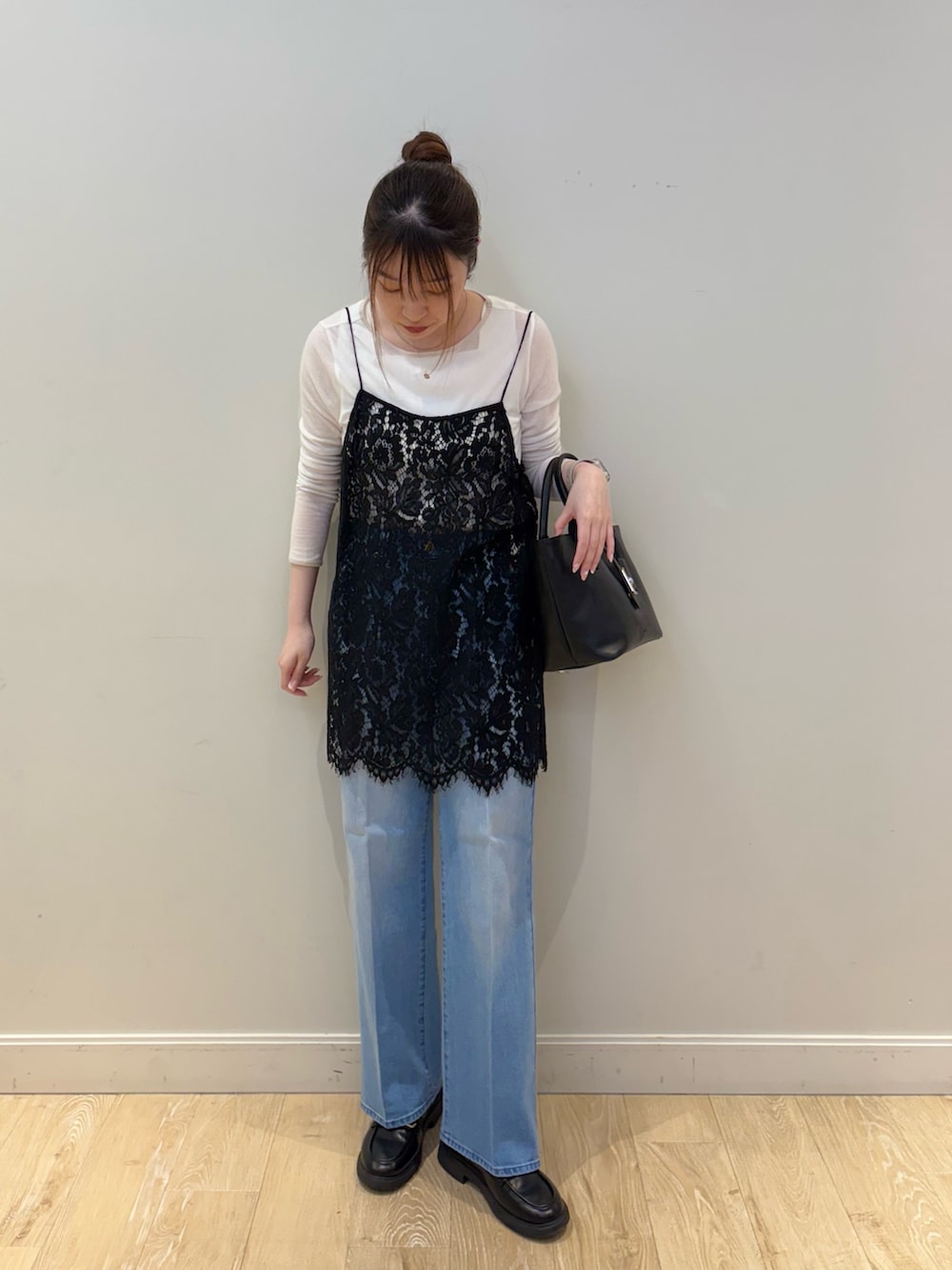 ブラック系のトートバッグ、ブルー系のデニムパンツ、ブラック系のキャミソールを着用したレディースの春コーディネートの4枚目の写真