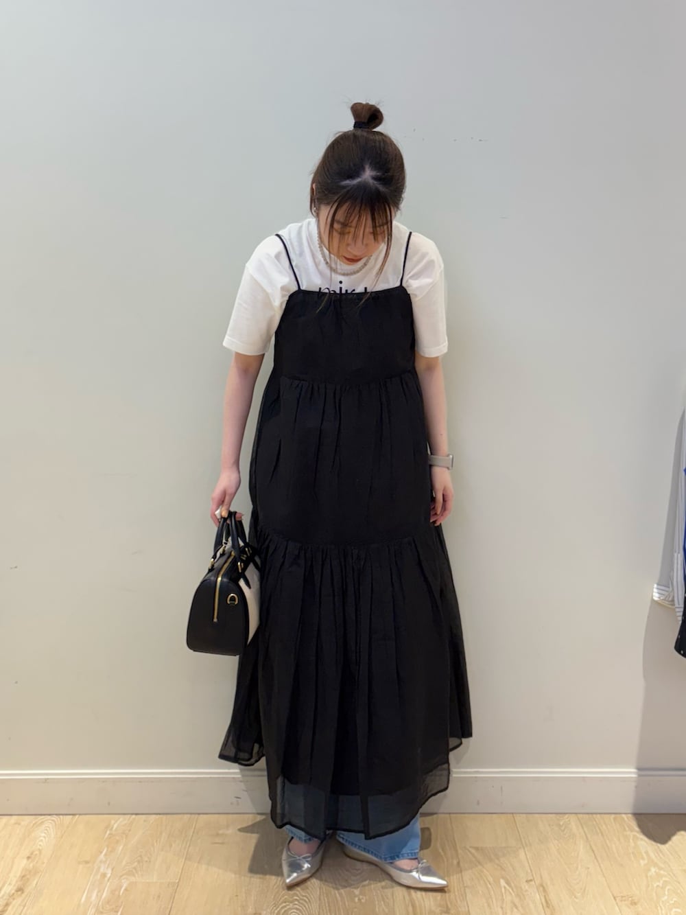 ブラック系のボストンバッグ、ホワイト系のTシャツ/カットソー、ブルー系のデニムパンツを着用したレディースの春コーディネートの4枚目の写真