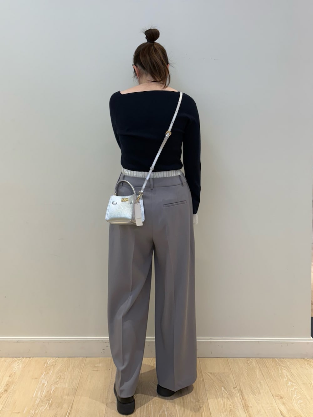 シルバー系のショルダーバッグ、ブルー系のニット/セーター、グレー系のその他パンツを着用したレディースの冬コーディネートの2枚目の写真