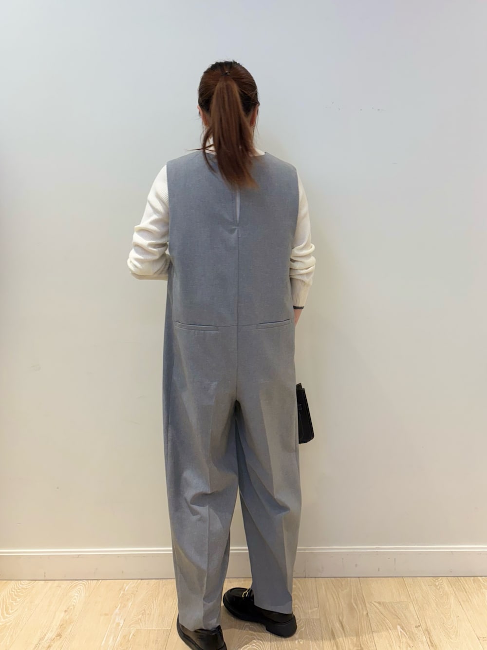 ブラック系のショルダーバッグ、ホワイト系のその他トップス、グレー系のつなぎ/オールインワンを着用したレディースの冬コーディネートの2枚目の写真