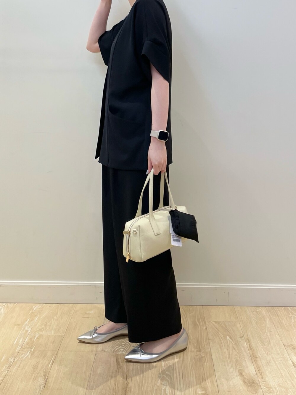 ブラック系のボストンバッグ、ブラック系のその他パンツ、ホワイト系のタンクトップを着用したレディースの春コーディネートの3枚目の写真