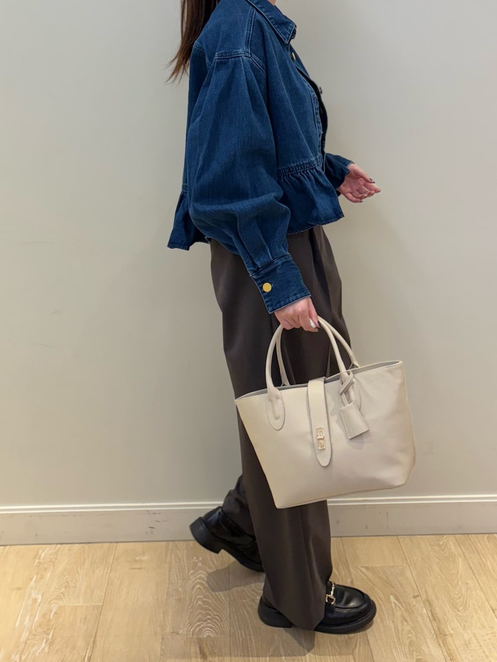 ブラック系のトートバッグ、ブルー系のブルゾン、グレー系のその他パンツを着用したレディースの冬コーディネートの3枚目の写真