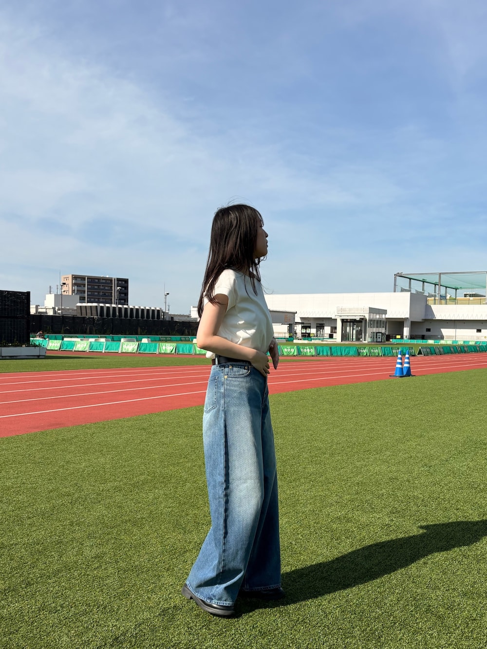 ホワイト系のTシャツ/カットソー、ブルー系のデニムパンツ、ブラック系のベルトを着用したレディースの夏コーディネートの4枚目の写真