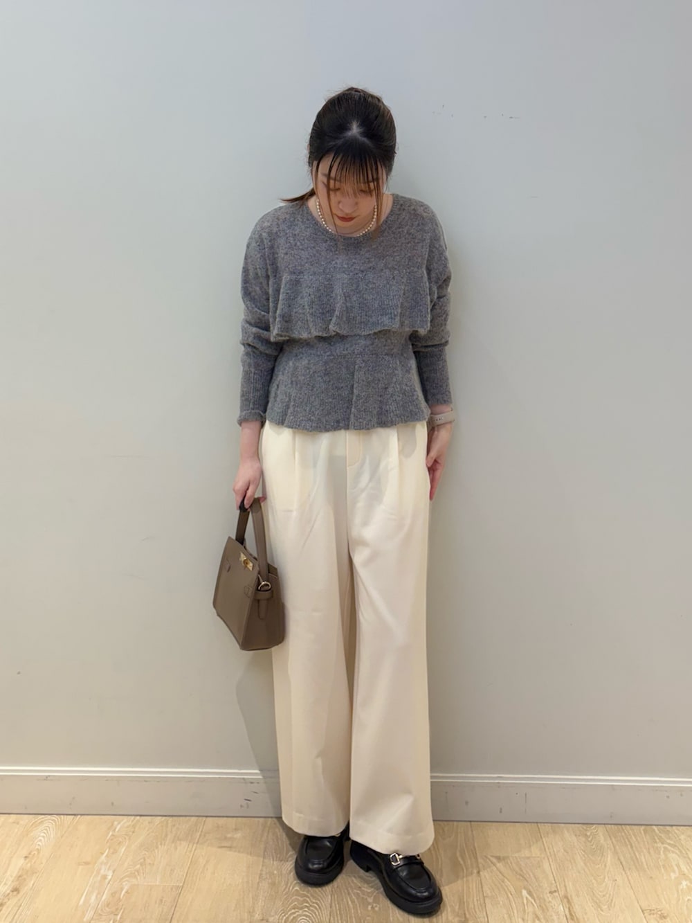 ベージュ系のショルダーバッグ、グレー系のニット/セーター、ホワイト系のその他パンツを着用したレディースの冬コーディネートの2枚目の写真