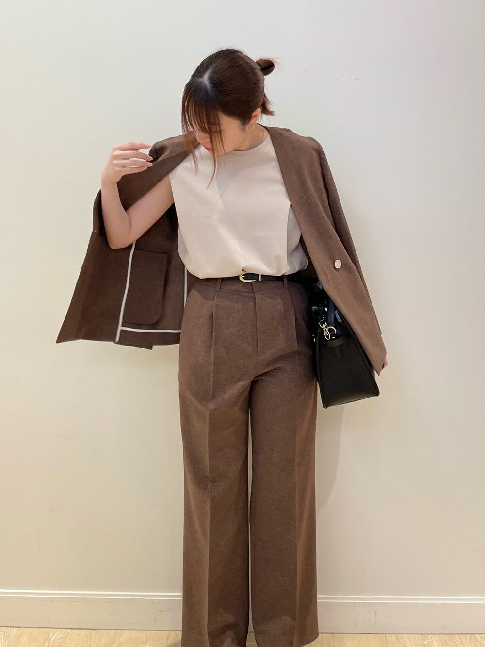 ブラウン系のその他パンツ、ブラック系のショルダーバッグ、ベージュ系のTシャツ/カットソーを着用したレディースの春コーディネートの2枚目の写真