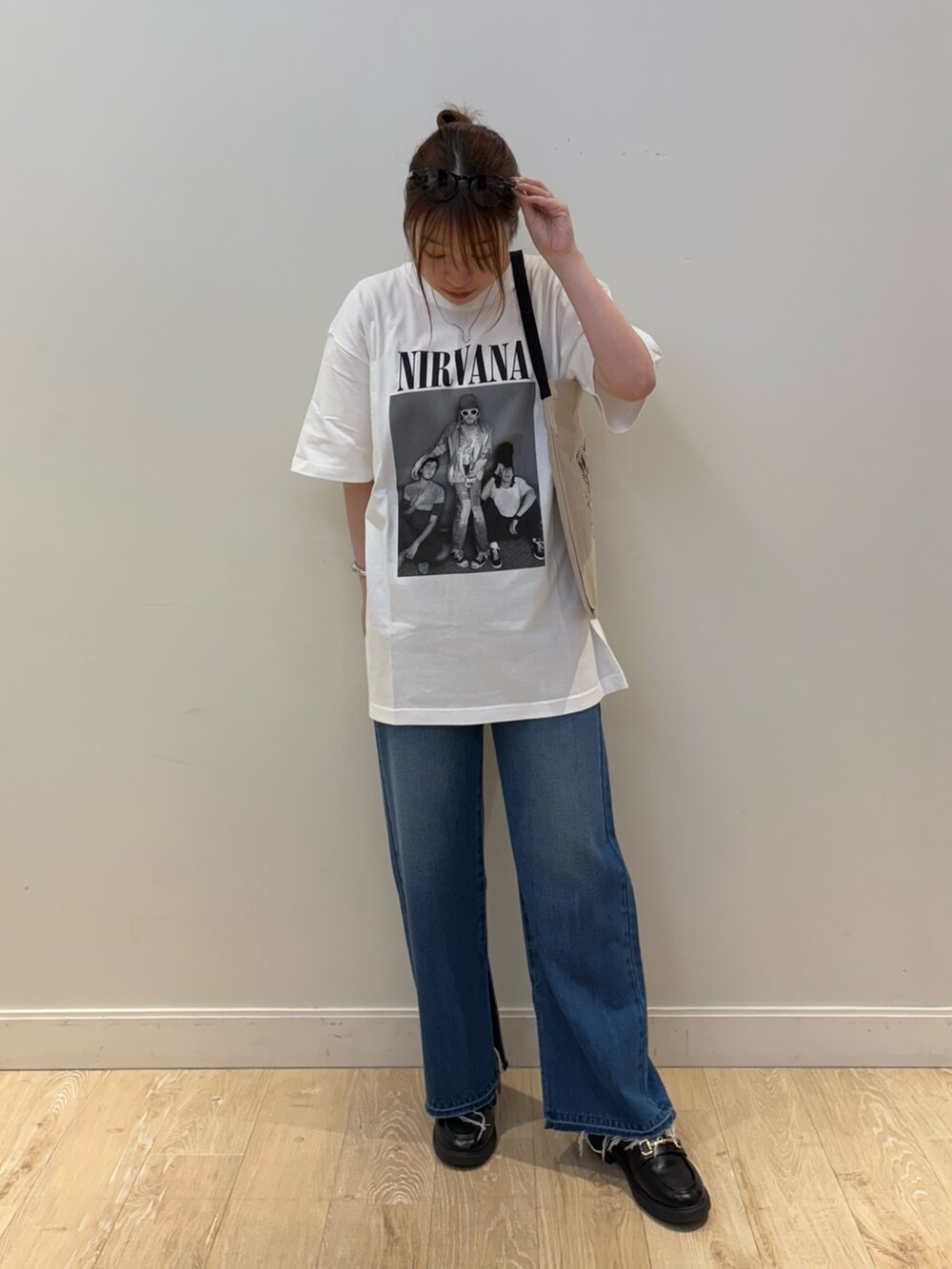 ブラック系のバックパック/リュック、ブルー系のデニムパンツ、ホワイト系のTシャツ/カットソーを着用したレディースの夏コーディネートの2枚目の写真