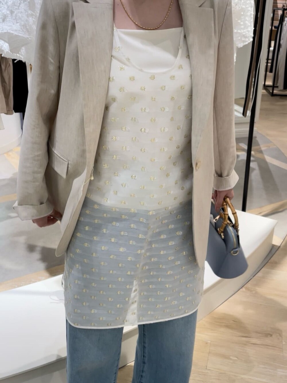 ベージュ系のテーラードジャケット、ホワイト系のシャツ/ブラウス、ホワイト系のキャミソールを着用したレディースの春コーディネートの5枚目の写真