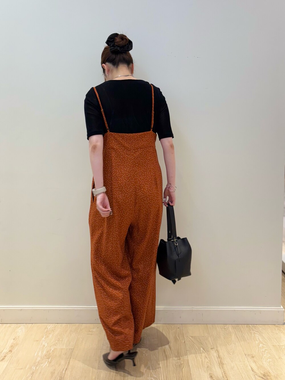 ブラック系のTシャツ/カットソー、ブラック系のショルダーバッグ、オレンジ系のつなぎ/オールインワンを着用したレディースの秋コーディネートの3枚目の写真