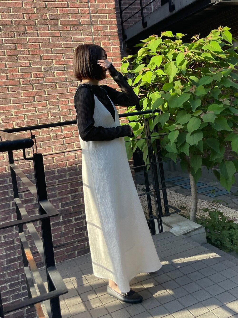 ホワイト系のワンピース、ブラック系のTシャツ/カットソーを着用したレディースの夏コーディネートの3枚目の写真