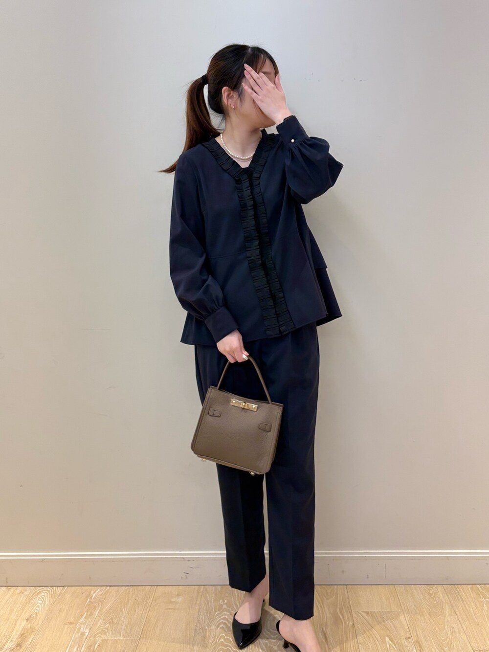 ベージュ系のショルダーバッグ、ブラック系のタンクトップ、ブルー系のシャツ/ブラウスを着用したレディースの冬コーディネートの4枚目の写真