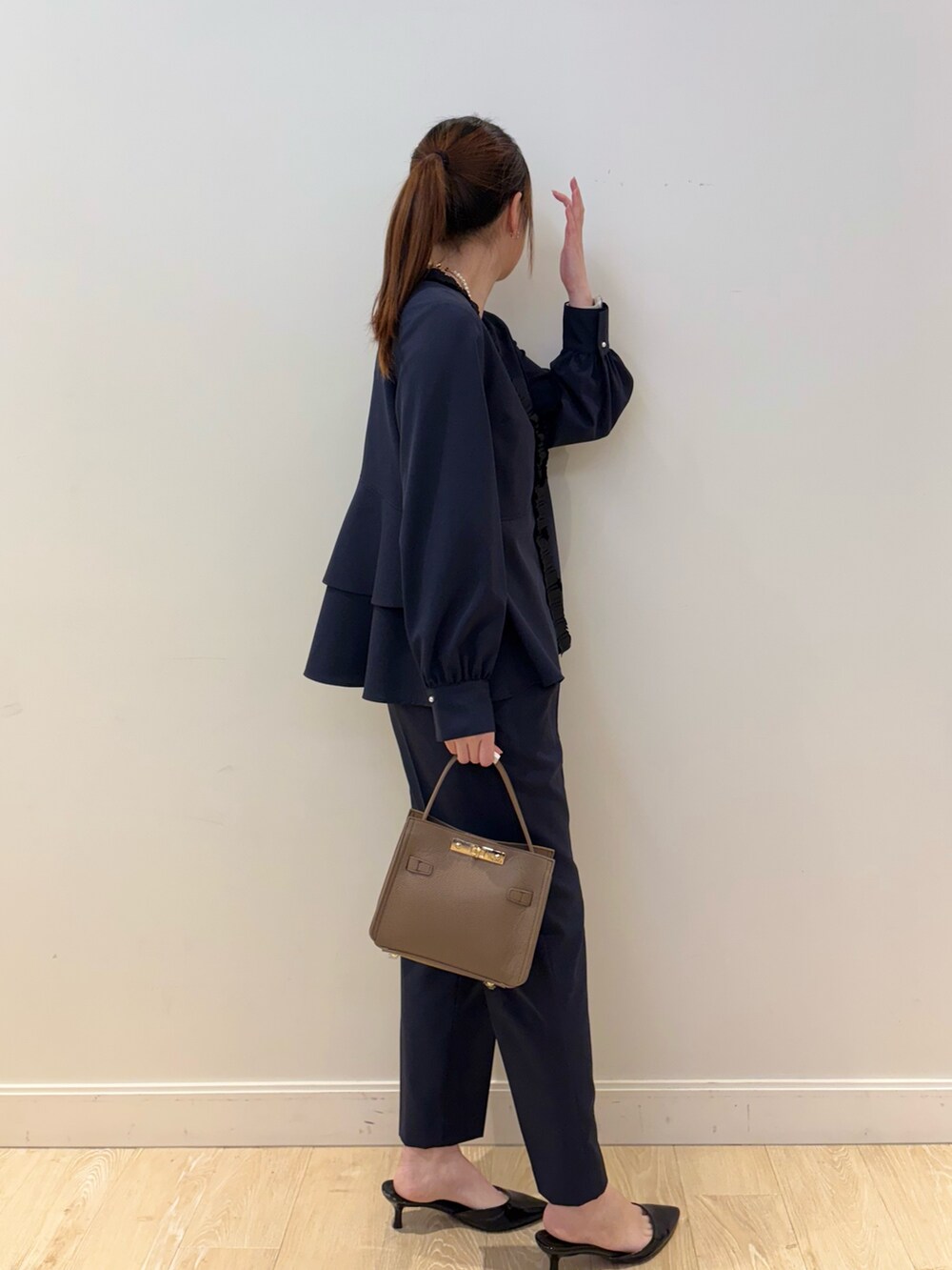 ベージュ系のショルダーバッグ、ブラック系のタンクトップ、ブルー系のシャツ/ブラウスを着用したレディースの冬コーディネートの3枚目の写真