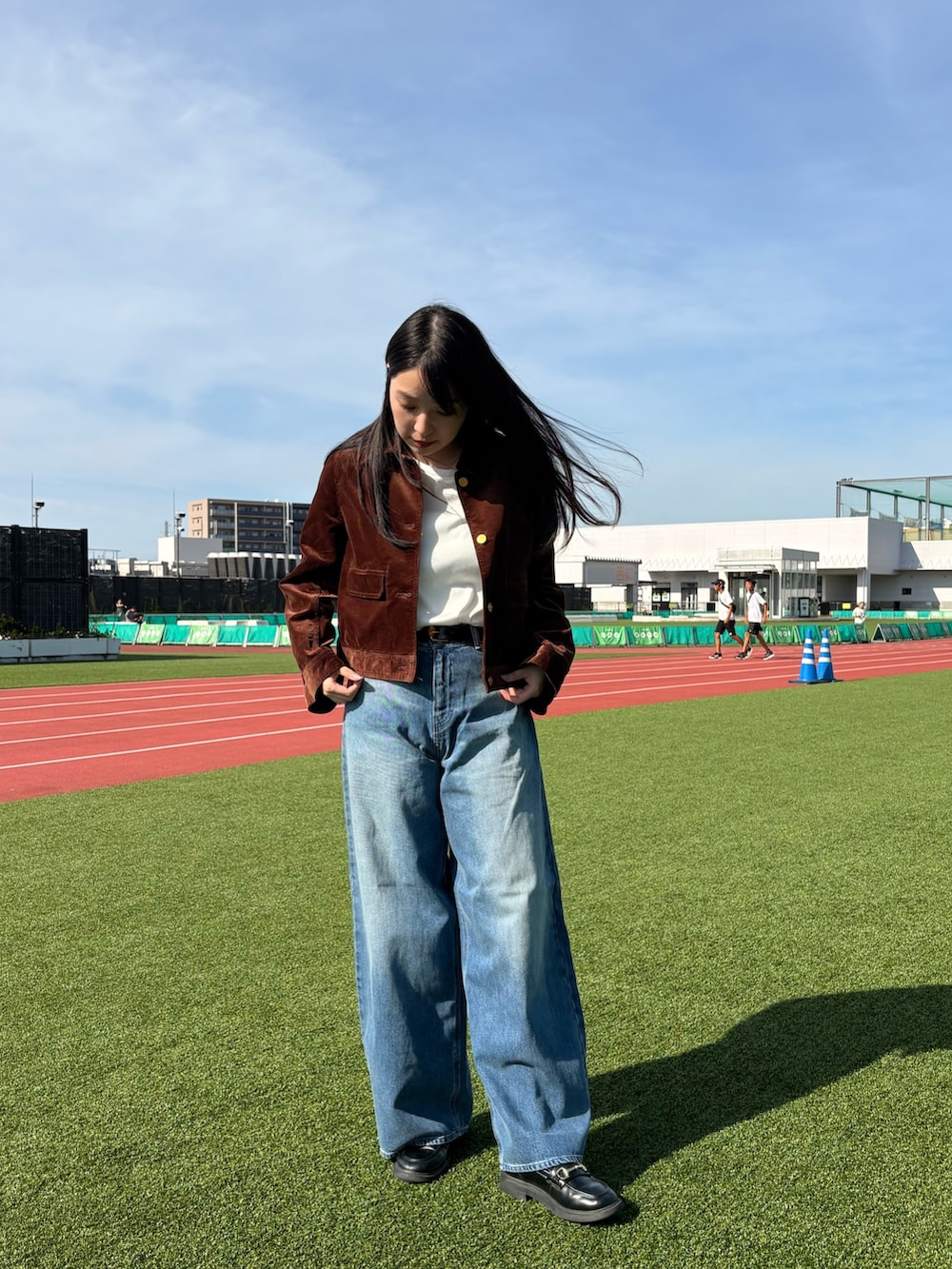 ブルー系のデニムパンツ、ホワイト系のTシャツ/カットソー、ブラウン系のブルゾンを着用したレディースの夏コーディネートの3枚目の写真
