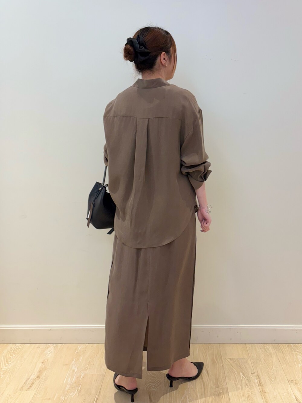 ブラック系のショルダーバッグ、ブラウン系のシャツ/ブラウス、ブラウン系のスカートを着用したレディースの秋コーディネートの3枚目の写真