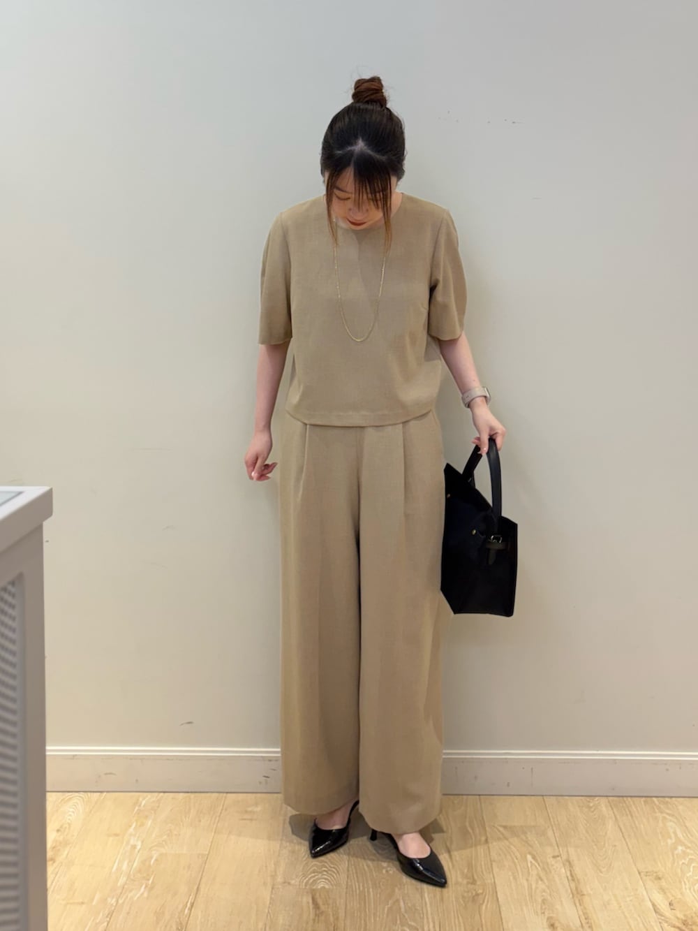 ブラック系のトートバッグ、ベージュ系のシャツ/ブラウス、ベージュ系のその他パンツを着用したレディースの春コーディネートの3枚目の写真