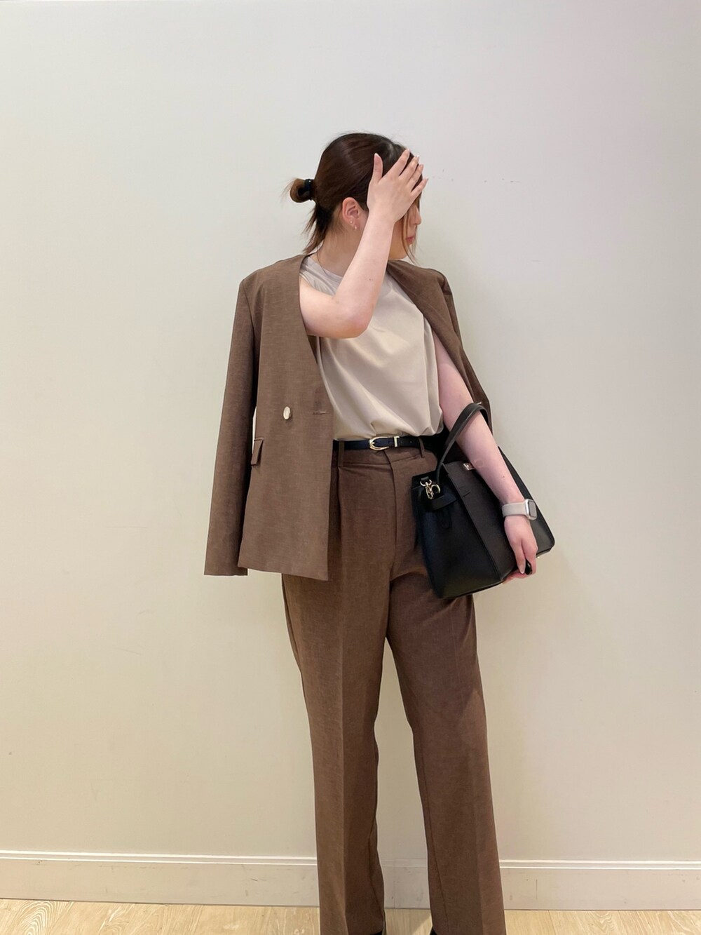 ブラウン系のその他パンツ、ブラック系のショルダーバッグ、ベージュ系のTシャツ/カットソーを着用したレディースの春コーディネートの4枚目の写真