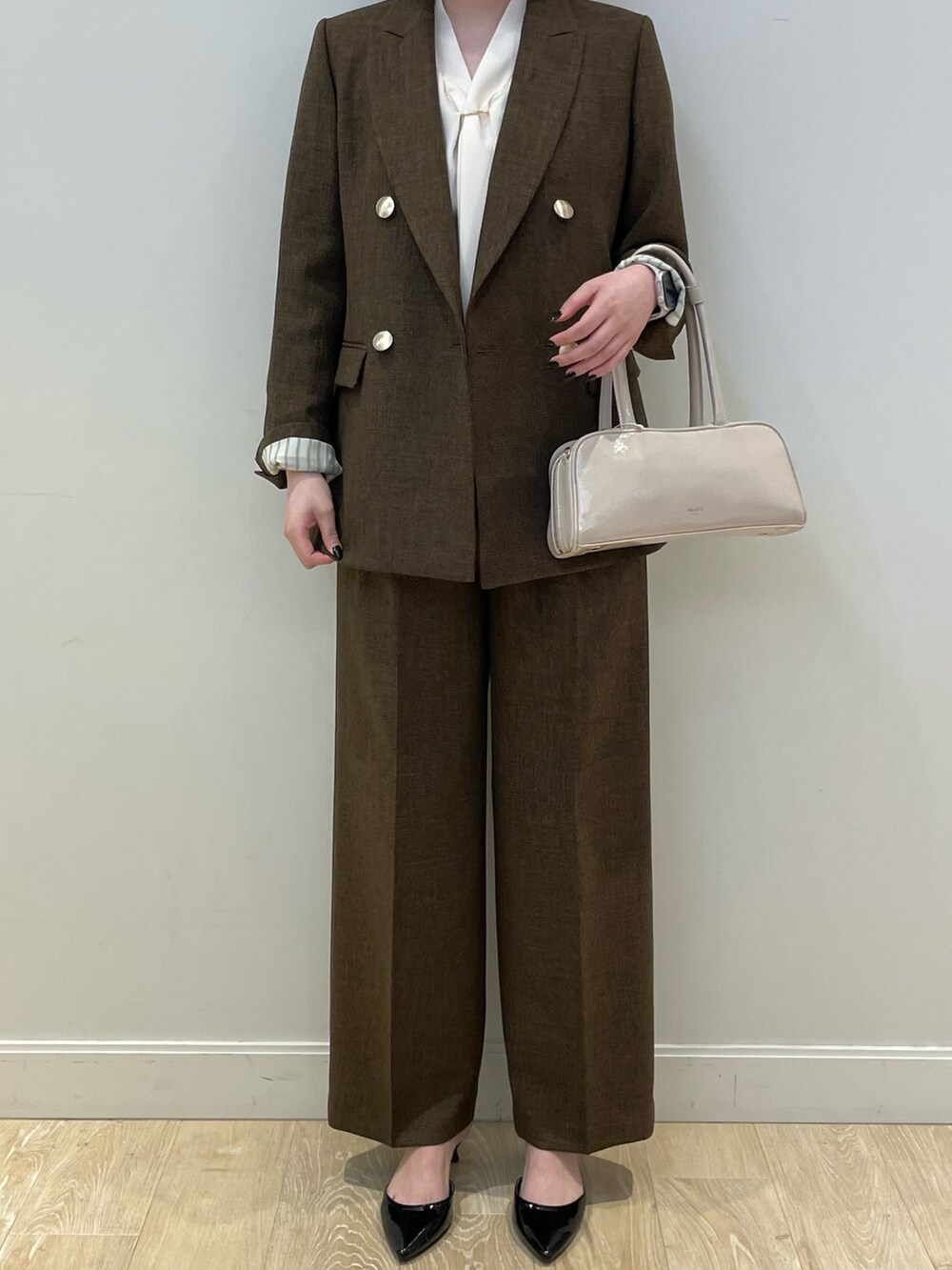 ブラウン系のテーラードジャケット、ブラウン系のその他パンツ、ホワイト系のシャツ/ブラウスを着用したレディースの夏コーディネートの4枚目の写真