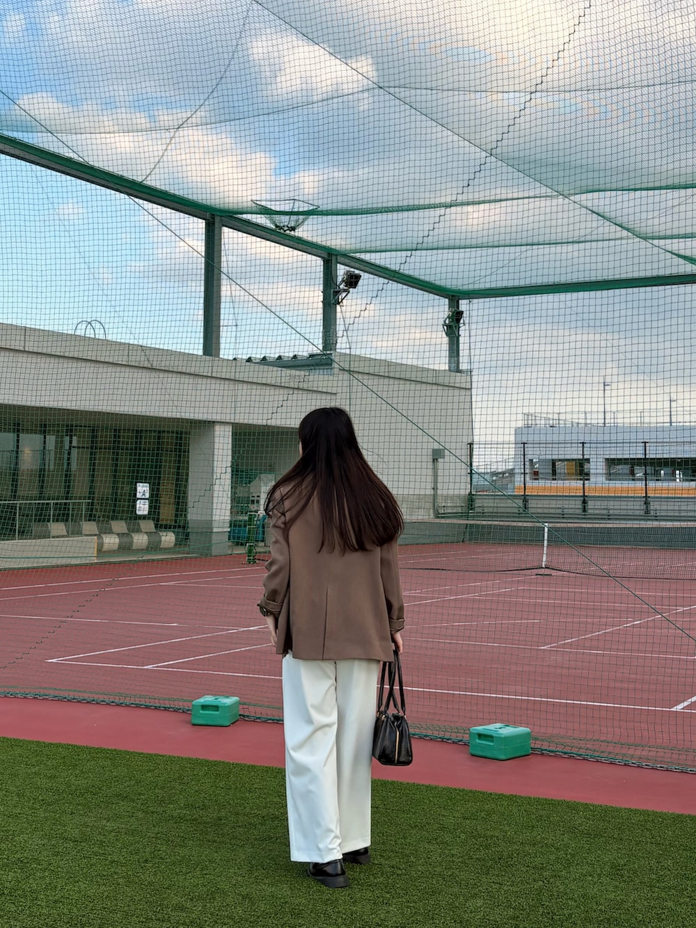 ブラック系のボストンバッグ、ホワイト系のその他パンツ、レッド系のニット/セーターを着用したレディースの秋コーディネートの2枚目の写真