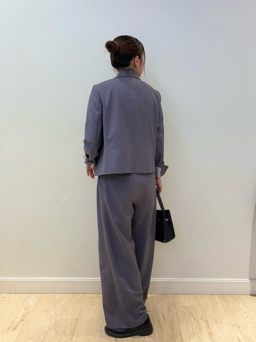 ブラック系のショルダーバッグ、ホワイト系のタンクトップ、グレー系のテーラードジャケットを着用したレディースの秋コーディネートの2枚目の写真