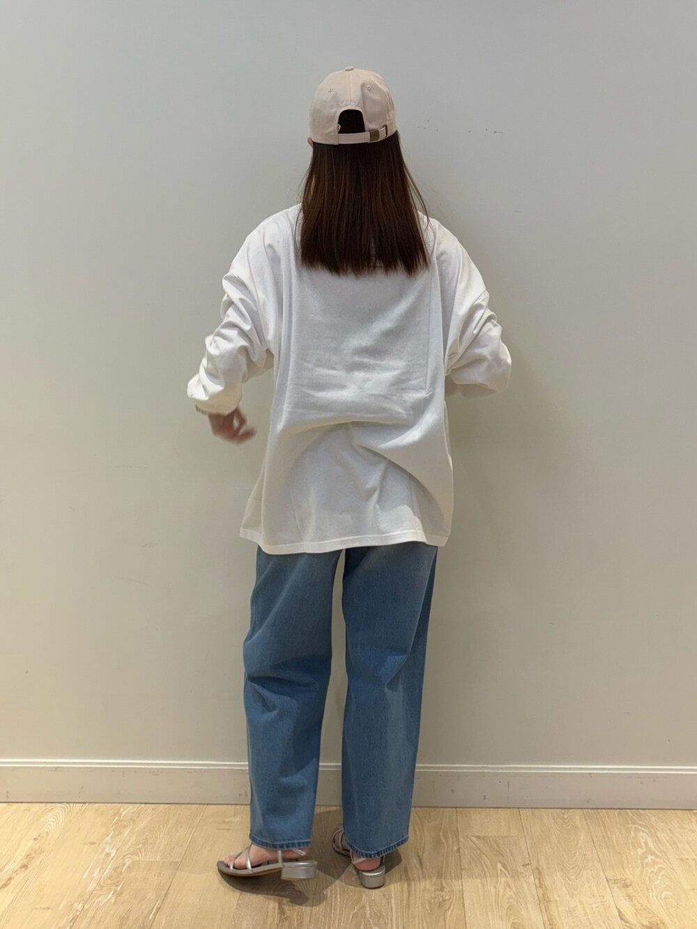 ブルー系のデニムパンツ、ホワイト系のTシャツ/カットソー、ピンク系のキャップを着用したレディースの秋コーディネートの2枚目の写真