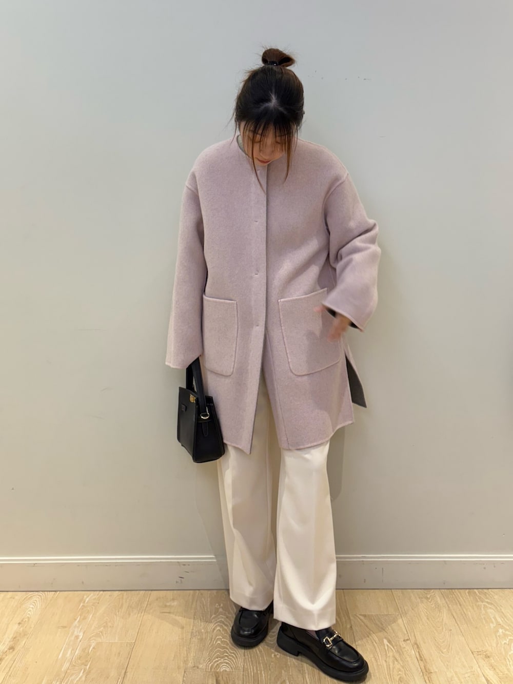 ベージュ系のニット/セーター、ホワイト系のその他パンツ、ブラック系のショルダーバッグを着用したレディースの冬コーディネートの3枚目の写真