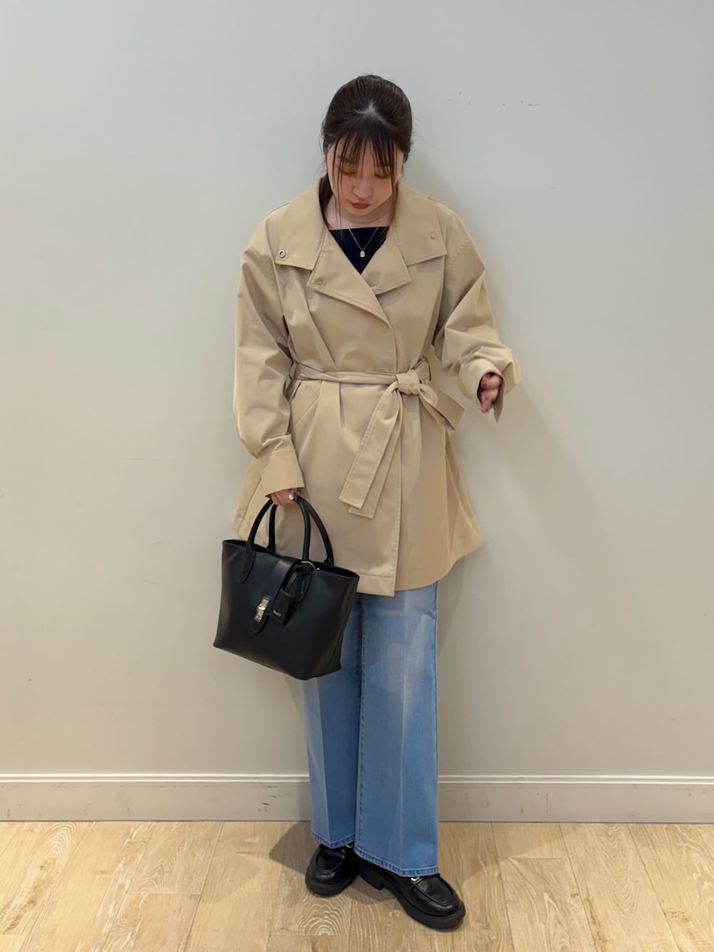 ブラック系のトートバッグ、ブルー系のデニムパンツ、ブルー系のニット/セーターを着用したレディースの冬コーディネートの4枚目の写真